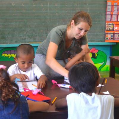 Une volontaire en mission humanitaire aux Philippines fait du dessin avec des enfants Une volontaire Projects Abroad dirige un atelier d'arts plastiques avec des enfants aux Philippines